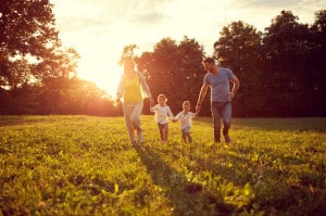 Happy children with parents running in park