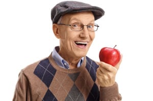 Cheerful senior having an apple